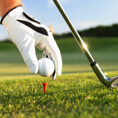 Image showing a man placing a golf ball on a golf tee